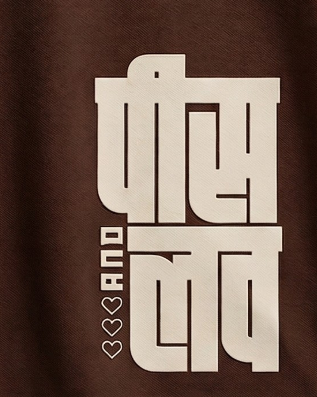 Brown t-shirt with off white text design on a gray background